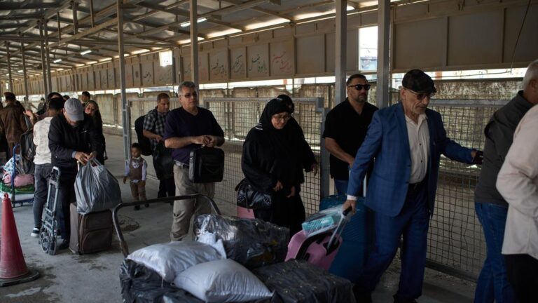 Carrying their belongings, people who arrived from Iran cross the Shalamcheh border crossing between Iran and Iraq, near Basra, Iraq, on March 29, 2026 | Photo Credit: AP